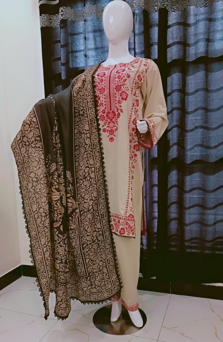 Mannequin wearing a cream kurta with pink embroidery and a brown embroidered shawl against a patterned curtain background.