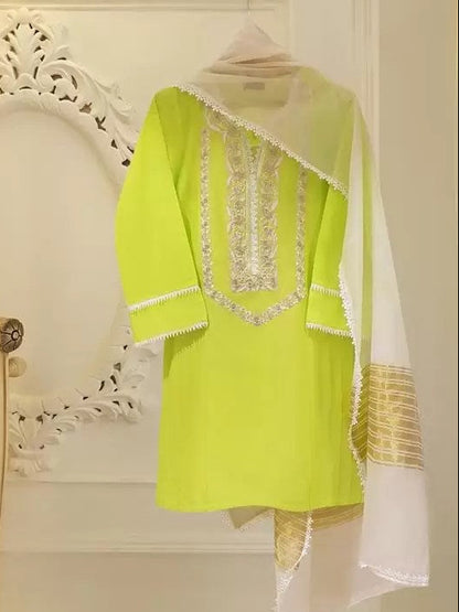 Green outfit with white dupatta hanging on a decorative wall