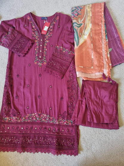 Purple embroidered outfit with matching pants and a pink dupatta on a neutral background